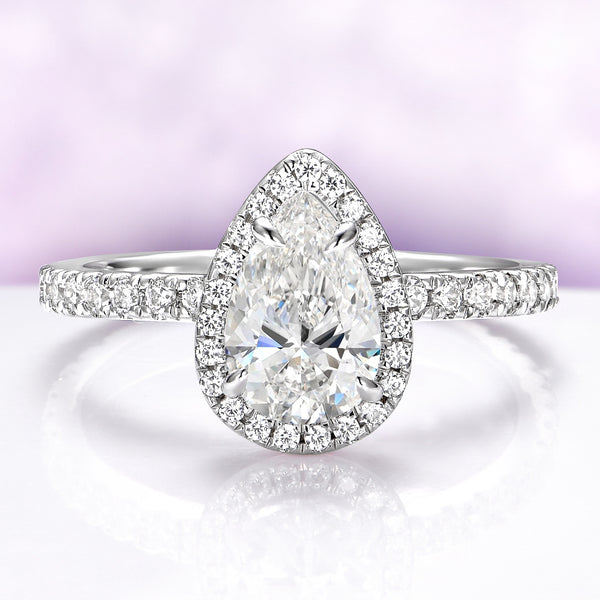 Diamond ring with a pear-shaped center stone on a light purple background