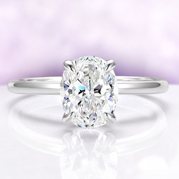 Diamond ring on a reflective surface with a light purple gradient background