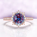 Aster Alexandrite Engagement Ring in 14K Rose Gold Vermeil by Aquamarise, featuring a round alexandrite center surrounded by a halo of white accent stones on a pavé band.