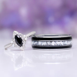 Arwen Black Onyx & Pearl Couples Ring Set by Aquamarise, featuring a marquise black onyx and pearl-accented silver ring paired with a silver band inlaid with white stone pieces.