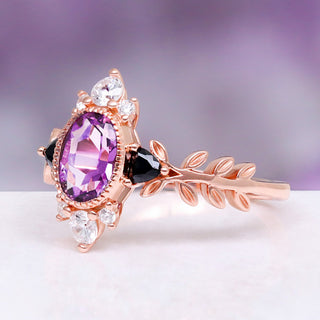 Aurelia Amethyst & Black Onyx Leaf Engagement Ring in 14K Solid Rose Gold by Aquamarise Gold, featuring an oval amethyst, black onyx accents, and a detailed rose gold leaf-inspired band.