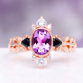 Aurelia Amethyst & Black Onyx Leaf Engagement Ring in 14K Solid Rose Gold by Aquamarise Gold, featuring an oval amethyst center flanked by black onyx and leaf-inspired band detailing.