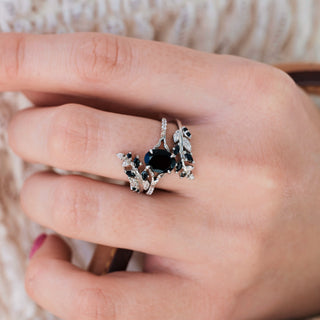 White gold ring set with oval cut natural black onyx center stone and accents on hand over a light background