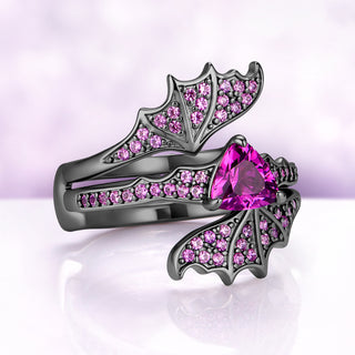 Angled view of the bat wing set showing the pink sapphire pavé along each wing and the trillion center