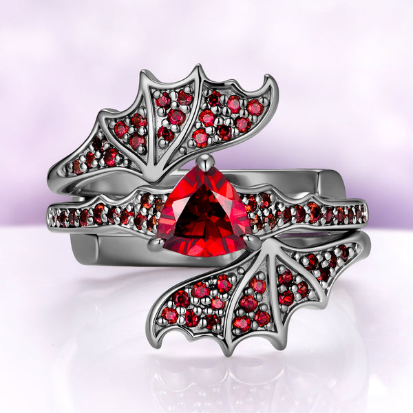 Garnet engagement ring set in black ruthenium — trillion natural garnet with pavé bat wings on the wrap band by Aquamarise