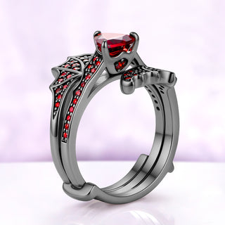 Side profile of the trillion garnet center ring nested between the two wings of the black ruthenium wrap band