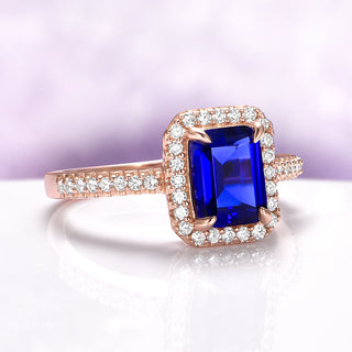 Emerald Cut Sapphire Ring in 14K Rose Gold Vermeil by Aquamarise, featuring a deep blue rectangular sapphire surrounded by pavé white stones on a delicate rose gold band.