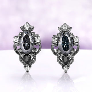 Carmilla gray moissanite stud earrings in black ruthenium, oval centers with black onyx pears and carved leaf and scroll frames