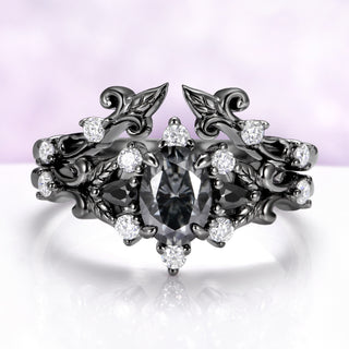 Carmilla gray moissanite engagement ring nested inside the matching leaf and vine enhancer band in black ruthenium
