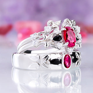 Angled view of the Carmilla ruby and black onyx couples ring set showing the carved leaf shoulders on all three sterling silver rings