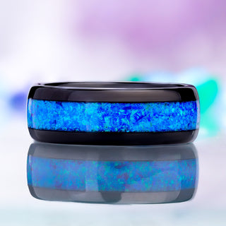 Front view of the polished black tungsten band showing the wide blue opal inlay between two narrow black rails