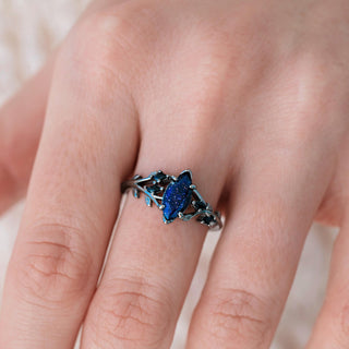 Close-up of a hand wearing a decorative ring with a blue gemstone.