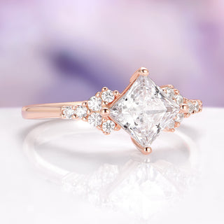 Rose gold ring with a large diamond and smaller diamonds on a soft purple background