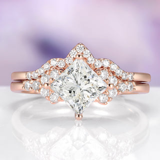 Rose gold diamond ring with a clear gemstone on a reflective surface with a blurred purple background