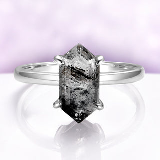 Silver ring with a large, rectangular, black diamond on a light purple background