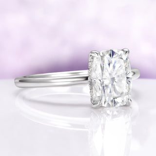 Diamond ring on a reflective surface with a light purple background