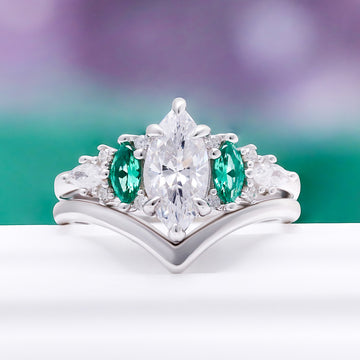 Emerie Diamond & Emerald Engagement Ring by Aquamarise, styled against green to highlight the emerald accents.