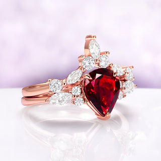 Evelyn Pear Red Garnet Engagement Ring Set in 14K Solid Rose Gold by Aquamarise Gold, featuring a pear-shaped red garnet and marquise and round white gemstones in a fantasy-inspired design.