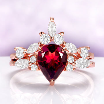 Evelyn Pear Red Garnet Engagement Ring Set in 14K Solid Rose Gold with a pear-shaped red garnet center and marquise and round white gemstones in an Aquamarise Gold design.