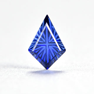 Faelight Cut lab-grown blue sapphire kite 7 x 10 mm loose gemstone, concave starburst facets, on white