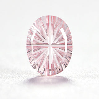 Faelight Cut lab-grown pink sapphire oval 6 x 8 mm loose gemstone, concave starburst facets, on white