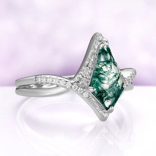 Angled view of the Faelyn moss agate ring, showing the fairy and leaf carving on the halo and the cubic zirconia strand of the band