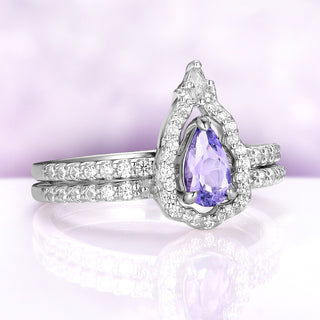 Angled view of the Fairest set showing the pear sapphire framed by the pavé mirror band