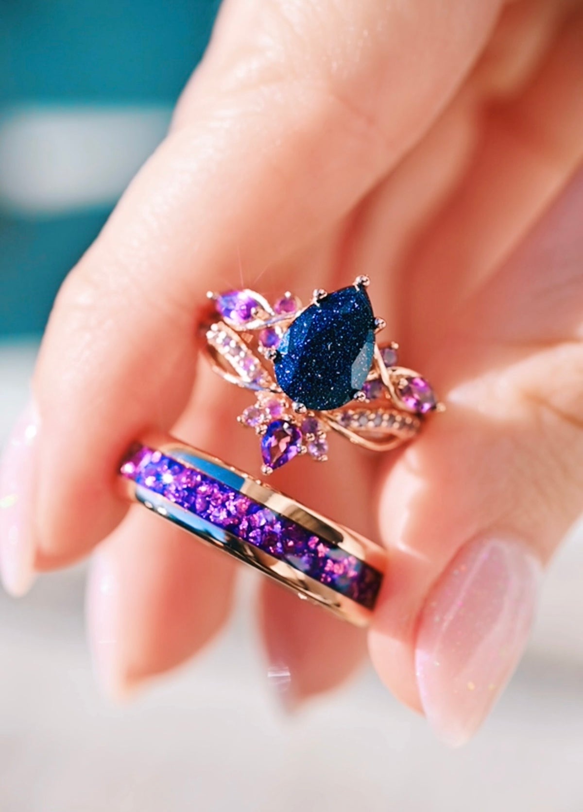 Close-up of a hand wearing two decorative rings with gemstones.