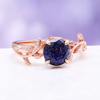 Front view of the leaf and vine shank cradling the sparkling blue galaxy sandstone center stone