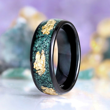 Green moss agate and gold leaf men's ring by Aquamarise displayed on a ring stand, showing the black band with gold leaf inlay
