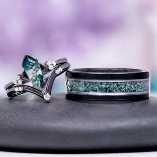 Two rings with turquoise and black design on a gray surface with a purple gradient background