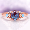 Alexandrite Crescent Moon Engagement Ring in 14K Solid Rose Gold by Aquamarise Gold, featuring an oval alexandrite center with crescent moon opal accents and small diamonds on a polished rose gold band.