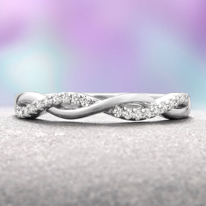 Silver ring with diamonds on a textured surface and blurred multicolored background