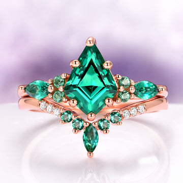 Skye Kite® Lab-Grown Emerald Engagement Ring Set in 14K Solid Rose Gold by Aquamarise Gold, featuring a striking kite-cut emerald surrounded by smaller emeralds and diamonds in rose gold.