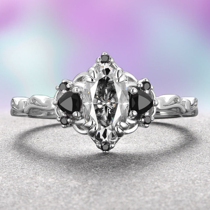 A 14K white gold ring with an oval-shaped gray moissanite center stone and black onyx accents on a plain background.