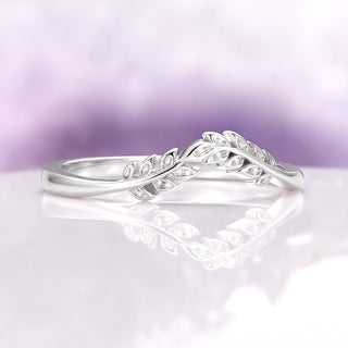 Filigree Leaf Wedding Band in 14K White Gold by Aquamarise Gold, featuring a delicate intertwined leaf design with intricate detailing on a reflective surface and soft lavender background.