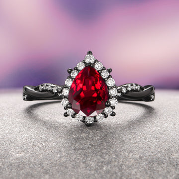 Briar Natural Red Garnet Couples Ring Set by Aquamarise featuring a pear-shaped red garnet center with diamond halo on black finish band, matching couples rings, elegant gemstone jewelry.