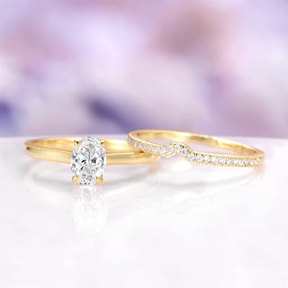 Two gold rings with diamonds on a white surface with a blurred purple background