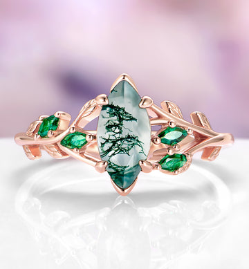 Moss Agate, Peacock Opal & Whiskey Barrel Wood Couples Ring Set featuring a marquise moss agate centerpiece with delicate green accents on a rose gold band, crafted by Aquamarise in a nature-inspired, matching design.
