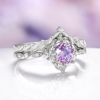 Silver ring with a purple gemstone on a reflective surface with a blurred background