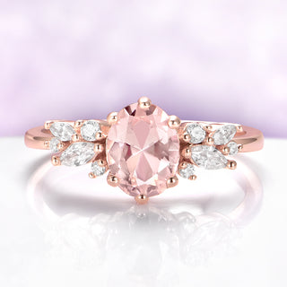 Rose gold ring with a pink gemstone and diamond accents on a light purple background
