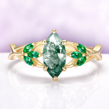 Moss Agate & Emerald Celtic Knot Ring in 14K Solid Yellow Gold by Aquamarise Gold, featuring a marquise moss agate center with emerald accents in a Celtic-inspired design.