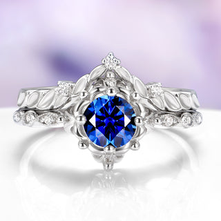 Elegant silver ring with a blue gemstone on a reflective surface