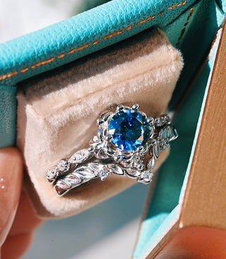Silver ring with a blue gemstone in a jewelry box