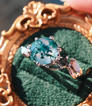 Gold ring with a large blue gemstone on a green cushion