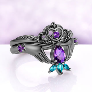 Angled view of the amethyst Claddagh ring set, showing the beaded crown band and the three teal marquise stones below the pear amethyst