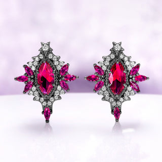 Nightbriar lab-grown ruby stud earrings in black ruthenium, marquise center stones in milgrain frames with ruby rays and a star crest