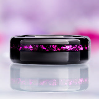 Front view of the polished black tungsten band showing the off-center crushed ruby channel and rounded dome profile
