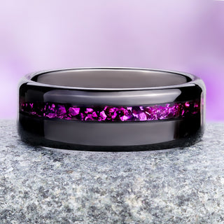 Crushed ruby black tungsten wedding band on granite, magenta-red inlay against the mirror-polished band