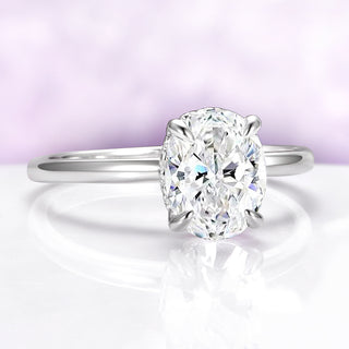 Diamond ring on a reflective surface with a soft purple background